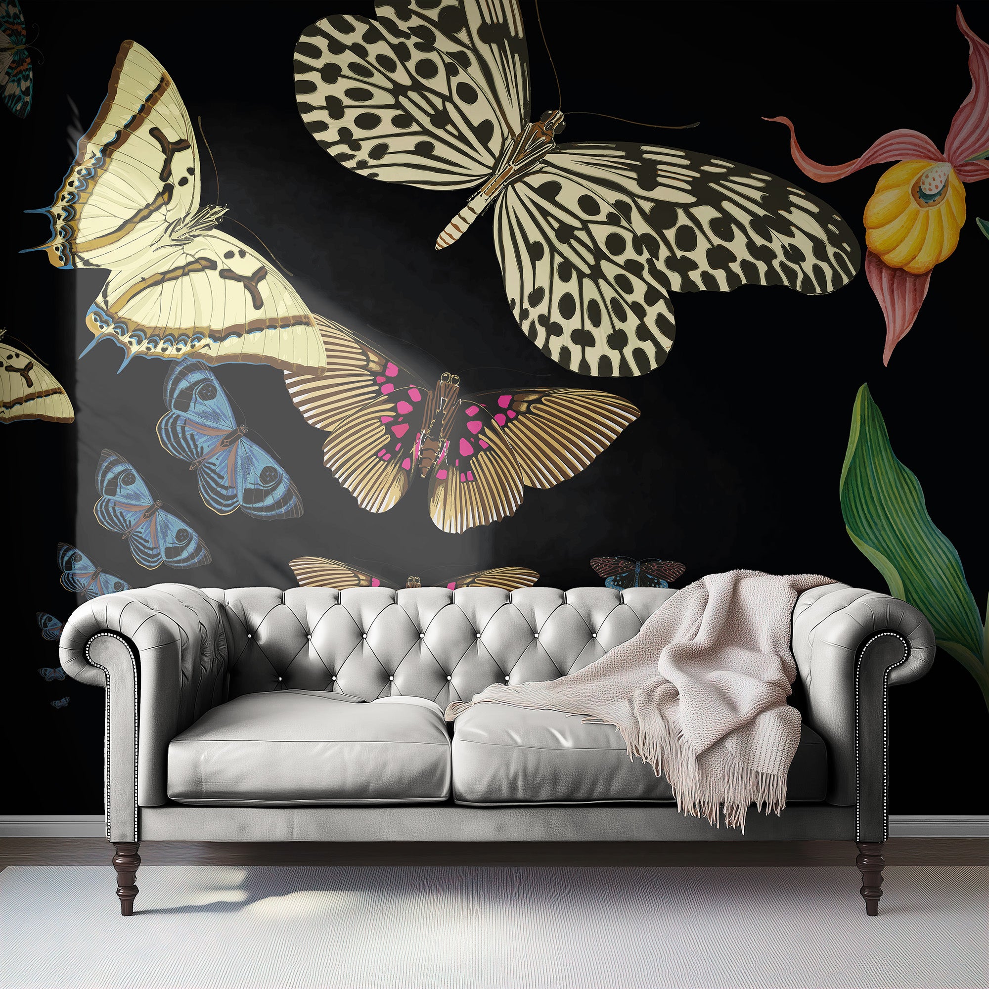 Gray sofa with a blanket against a wall featuring colorful butterfly designs.
