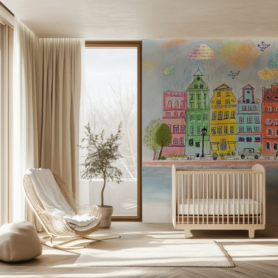 Modern nursery with a crib, chair, and colorful wall mural of buildings.